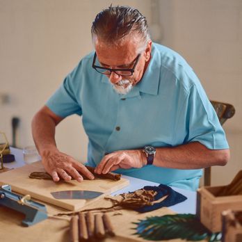 Rod, founder of Cigar Haus, carefully crafting a cigar at his workbench